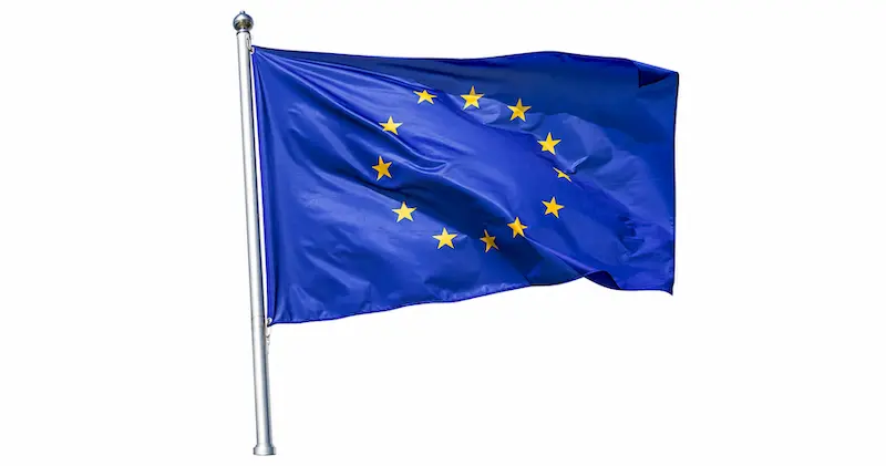 Bandiera dell’Unione europea davanti a un edificio istituzionale.